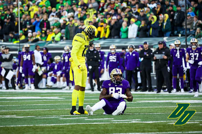 Oregon Ducks safety Bryan Addison stands over Washington Huskies tight end Devin Culp.